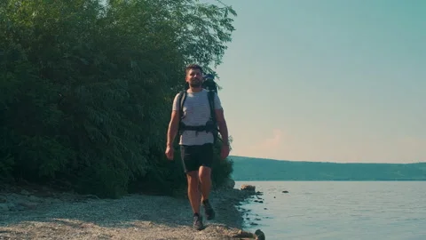 The man with backpack trekking along the beautiful coast. slow motion Stock Footage 159732236