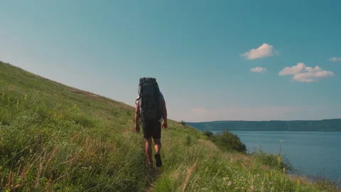 The man with backpack trekking along the beautiful coast. slow motion Stock Footage 159732298