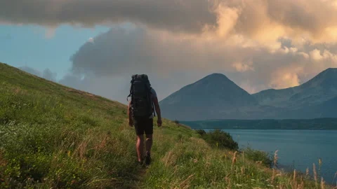 The man with backpack trekking along the mountain coast. slow motion Stock Footage 203492256