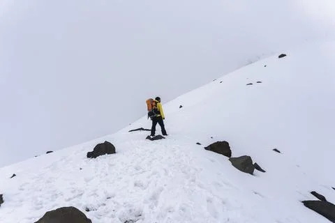 Man with backpack trekking in mountains Stock Photos