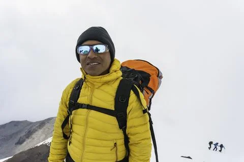Man with backpack trekking in mountains Stock Photos