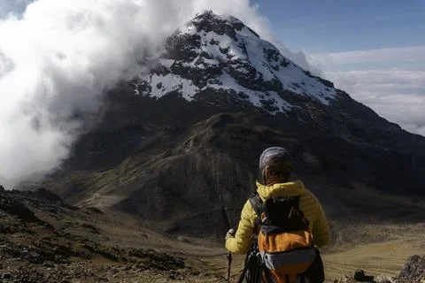 Man with backpack trekking in mountains Stock Photos
