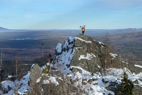 Man with backpack trekking in mountains at winter. Hiker at the top the rock Stock Photos