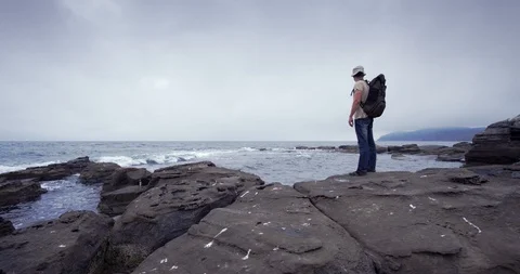 A man with a backpack walkig along the coast. Russky Island, The Sea of Japan  Stock Footage 100762505