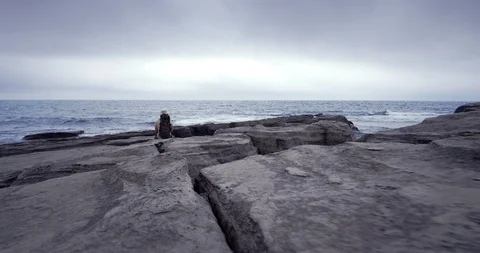 Man with a backpack walkig along the coast. Russian Far East, Pacific, Steadycam Stock Footage 100778296