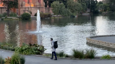 Man with a backpack walking around Palace of Fine Arts San Francisco Видео 144401462