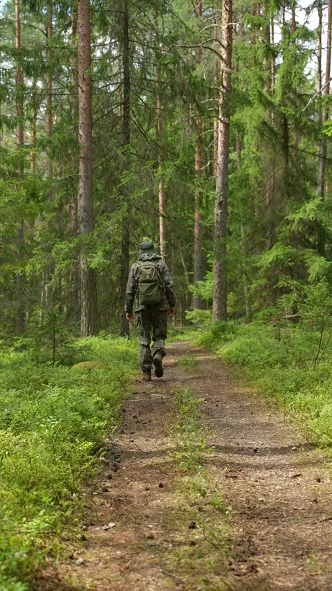Man with a backpack walking away down a dirt road Stock Footage 340653407