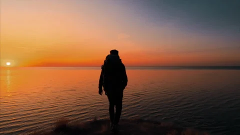The man with backpack is walking on the mountain near the sea. slow motion Stock Footage 151351399