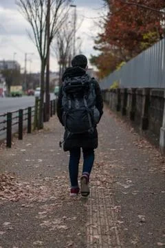 A man with backpack walking through a pedestrian walkway in japan Stock Photos