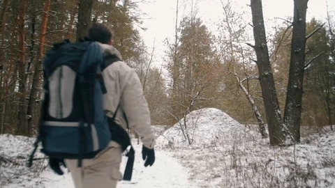 A man with a backpack is walking through the winter forest. Solo hike, Stock Footage 124593956