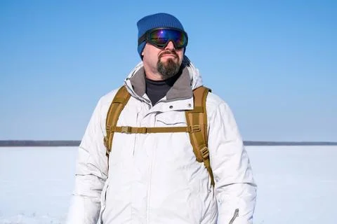 Man with backpack walking in winter snowy nature. Traveler enjoying hiking .. Foto stock