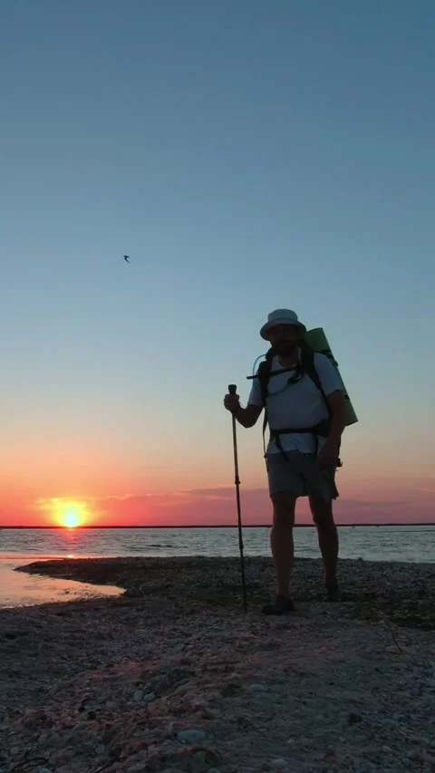 A man with a backpack walks along the Kinburn Spit early in the morning. Ve.. Video stock 270516688