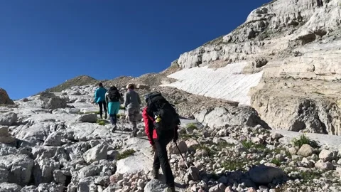 A man with a backpack walks along a mountain path Stock Footage 144116979