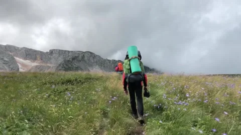 A man with a backpack walks along a mountain path Stock Footage 144117113