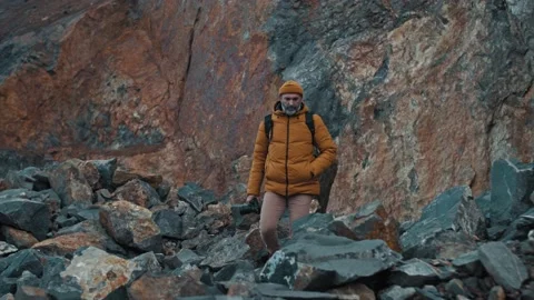A man with a backpack walks along a mountain path. Holidays in the mountains Stock Footage 154615842