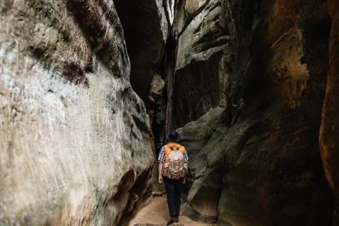 A man with a backpack walks down a mountain gorge. Weekend trips Stock Photos
