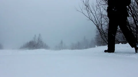 Man with Backpack Walks through Snowy Area. Snowstorm. Bad Visibility. Winter Stock Footage 146948071