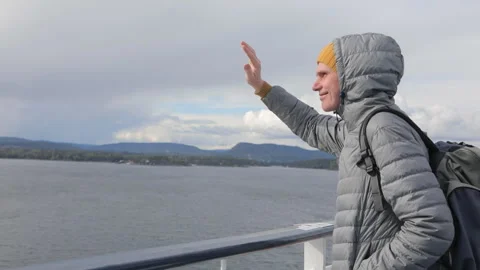 Man with backpack waving from the deck of outgoing ship Stock-Footage 129653746