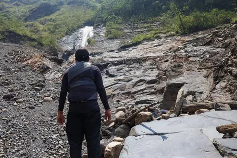 Man with a backpack wearing a black cap dressed in trekking clothes standin.. Stock Photos