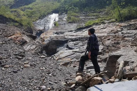 Man with a backpack wearing a black cap dressed in trekking clothes standin.. Foto stock