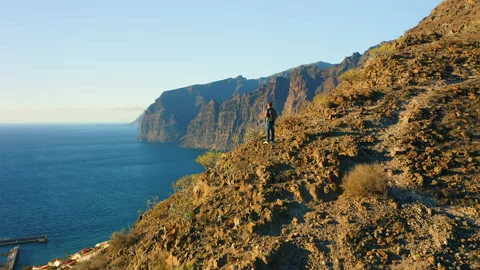 Man backpacker standing on mountain rock and enjoying epic viewpoint colorful Video stock 227010529