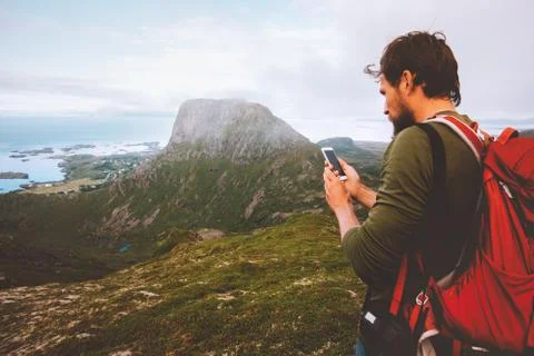 Man backpacker using smartphone navigation hiking in mountains travel blogger Stock Photos