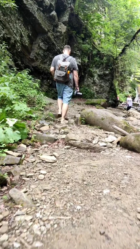 Man backpacker walking to waterfall Stock Footage 169222204