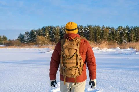 Man backpacking through a pristine snowy winter landscape, experiencing adv.. Foto stock