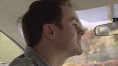 Man Backs Up Into Parking Spot, In City, He Looks Over His Shoulder Video stock 76012276
