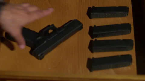 Man with bad intentions taking a gun from his drawer Stock Footage 64378884