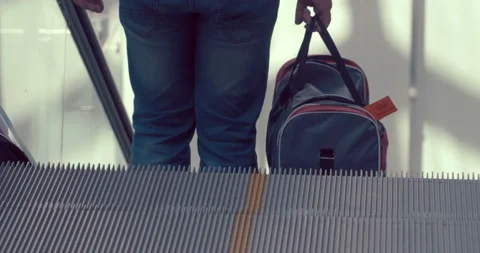 A man with a bag goes down the escalator Stock Footage 119594406