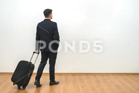 The man with a bag standing on the white wall background Stock Photos
