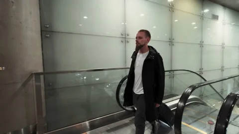 Man with baggage moving up on escalator. Subway underground station Stock Footage 132019160