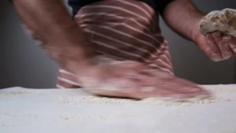 Man baker distributes flour and puts raw dough on table Vídeo Stock 168823169