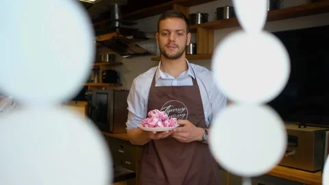 Man baker or pastry chef with marshmallow dessert in bakery Stock-Footage 135710885