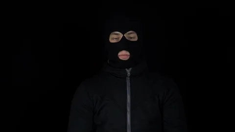 A man in a balaclava mask is standing with a bundle of euro. The thug leafing Stock Footage 124225594