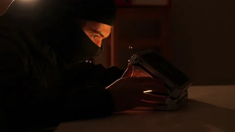 Man in a balaclava opens a treasure box Stock Footage 237644692