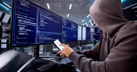 Man In Balaclava Stealing Data From Stolen Mobile Phone Screen. Stock-Fotos