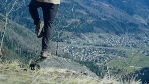 Man Balancing on Rock in Mountain Clearing with Valley and Town Background Stock Footage 316417043
