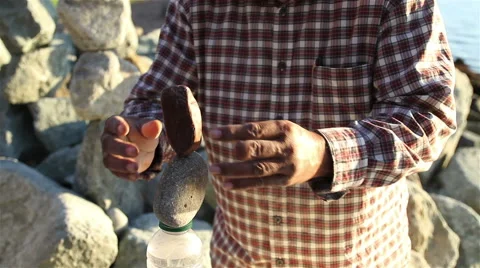 Man Balancing Rocks Along the Beach Stock Footage 40778611
