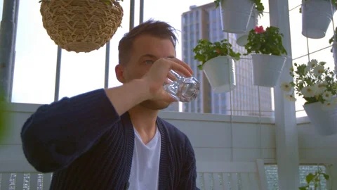 Man on balcony is drinking water Stock Footage 103142456