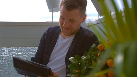 Man on balcony is looking on tablet Stock Footage 103142427