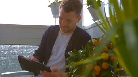 Man on balcony is looking on tablet Stock Footage 103142434