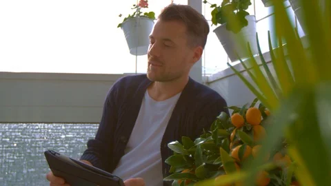 Man on balcony is looking on tablet Stock Footage 103142436
