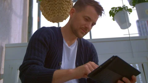 Man on balcony is looking on tablet Stock Footage 103142474