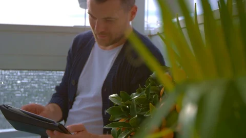 Man on balcony is looking on tablet Stock Footage 103142485