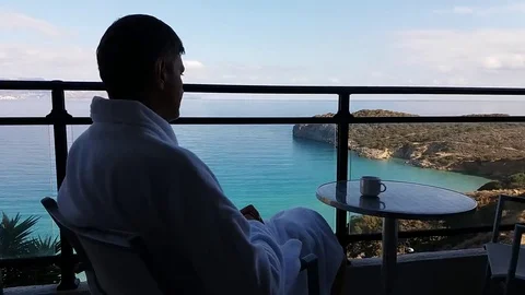 The man on the balcony with the sea view drinking coffee Stock Footage 69221462