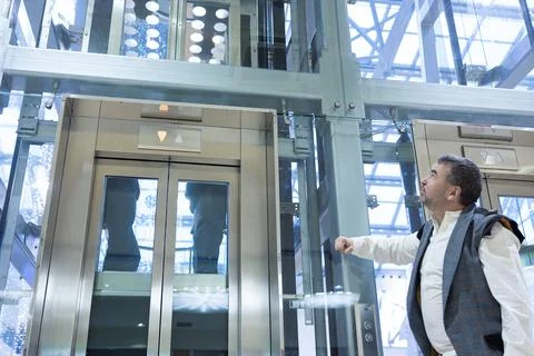 Man banging his fist on elevator panel Stock-Fotos