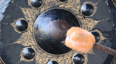 A Man bangs on a large Antique Thai Gong( Bell) Stock Footage 24827674