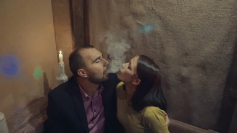 A man in a bar drinks whiskey and smokes a cigarette 스톡 동영상 95938293